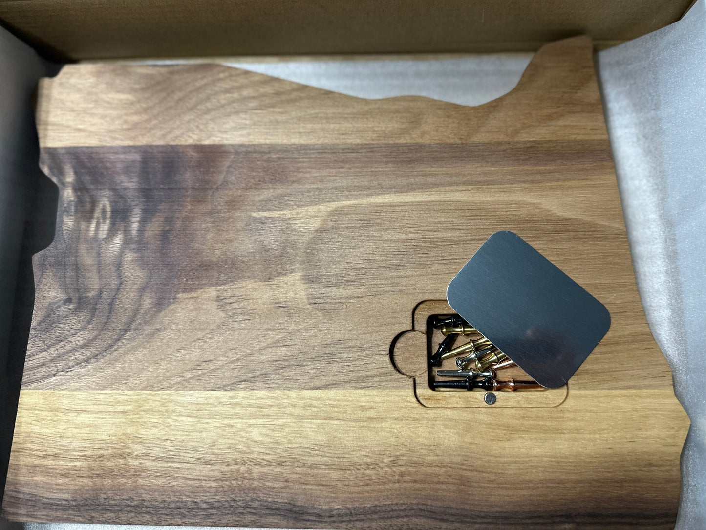 Back of cribbage board state of Oregon shape displaying peg pocket with magnetic metal cover & pegs