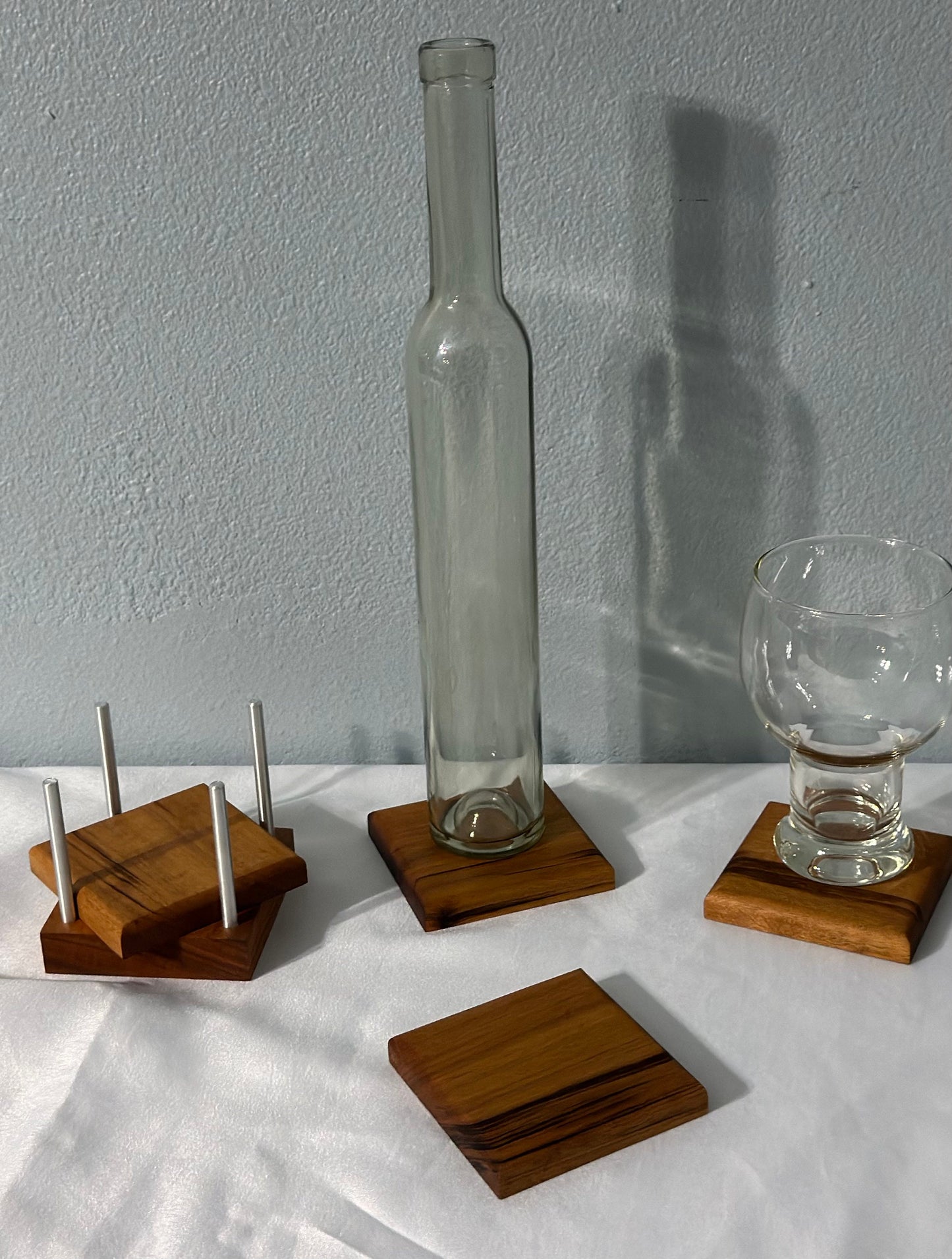 Three Brazil wood coasters sat out on white linen.