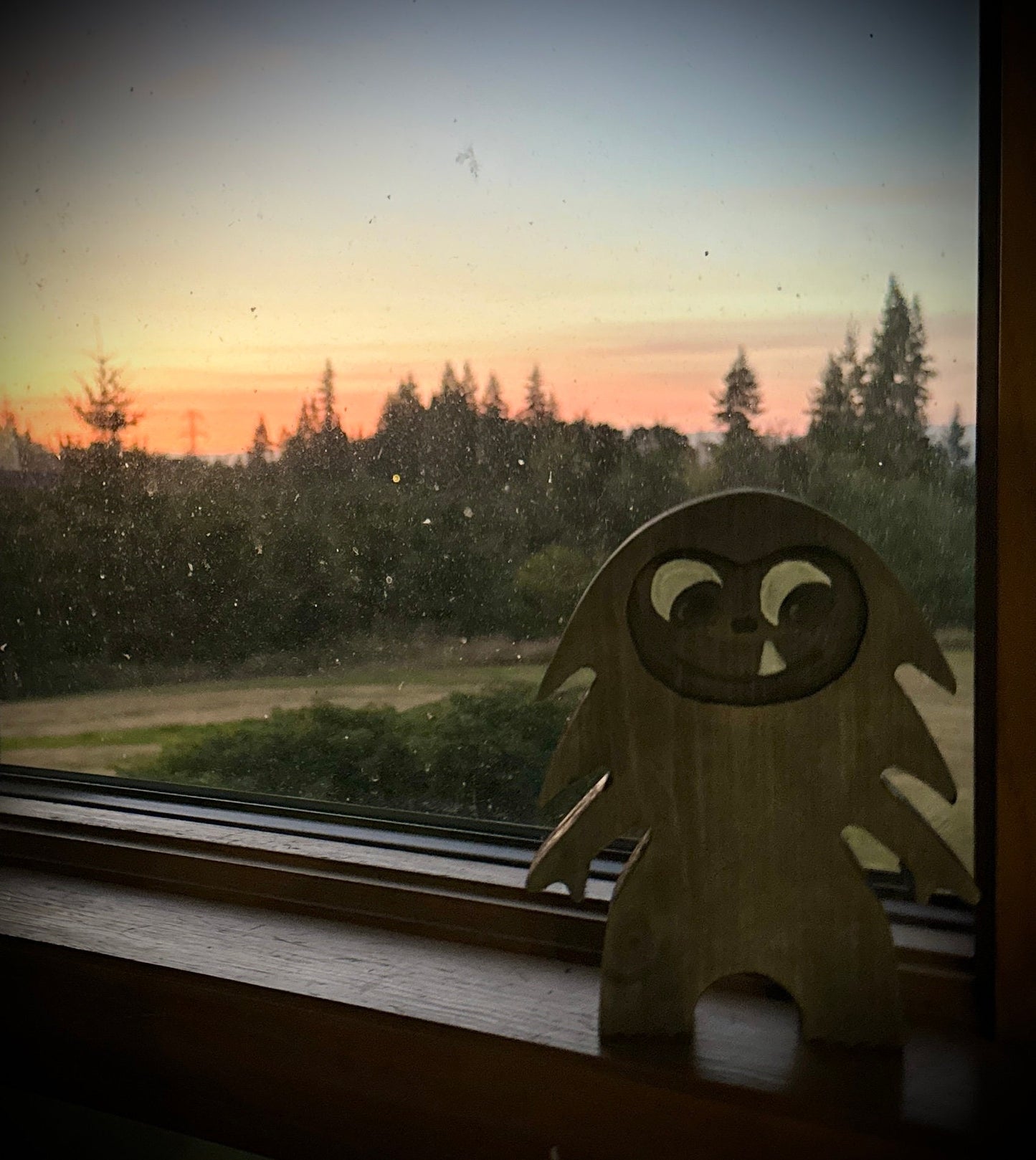 Hardwood Large Bigfoot in blue pine with walnut stain sitting on windowsill with forest setting sun view