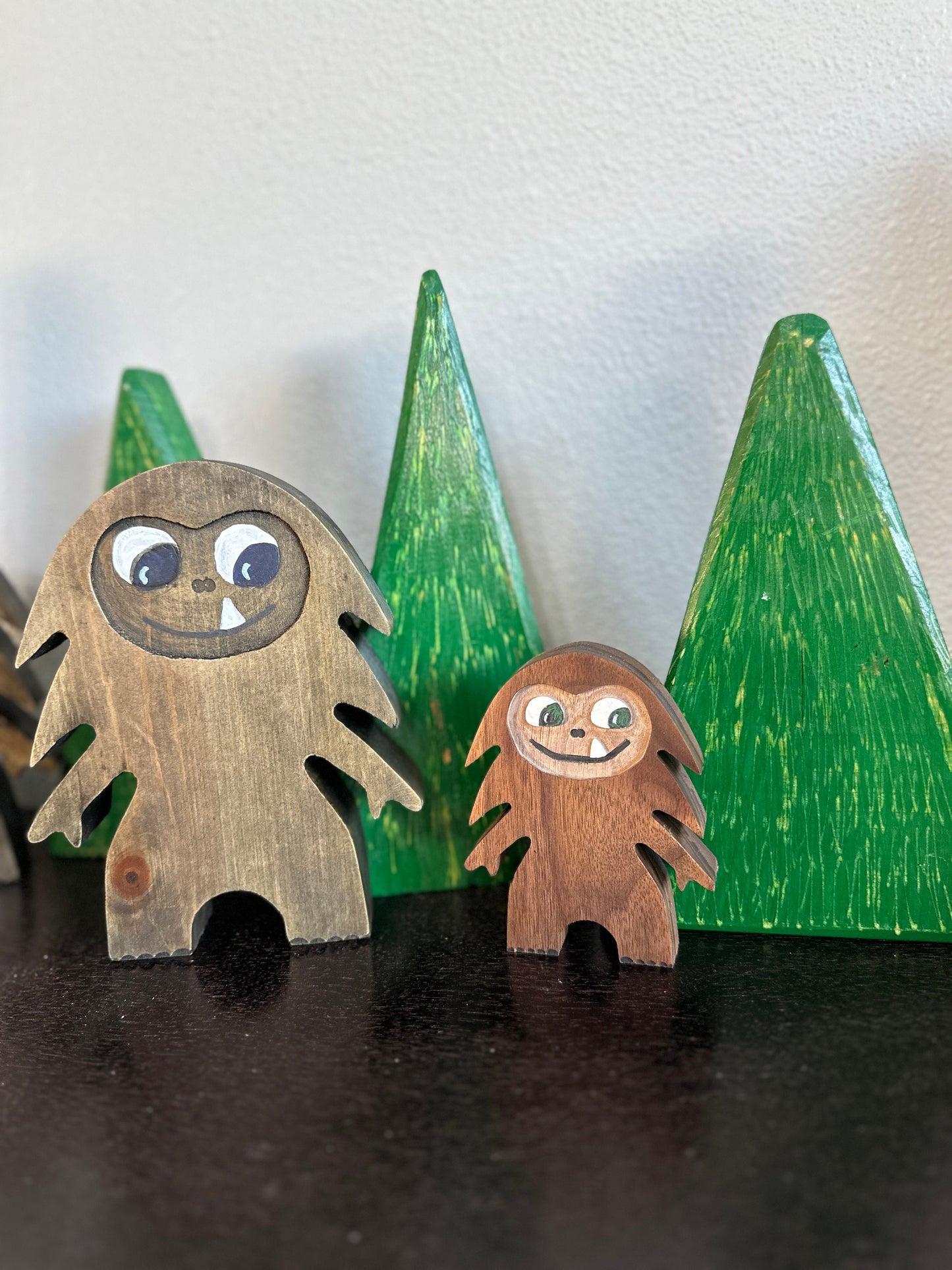 Hardwood large and small Bigfoot in blue pine and walnut with smiling one-tooth mouth, background of green triangle hardwood trees