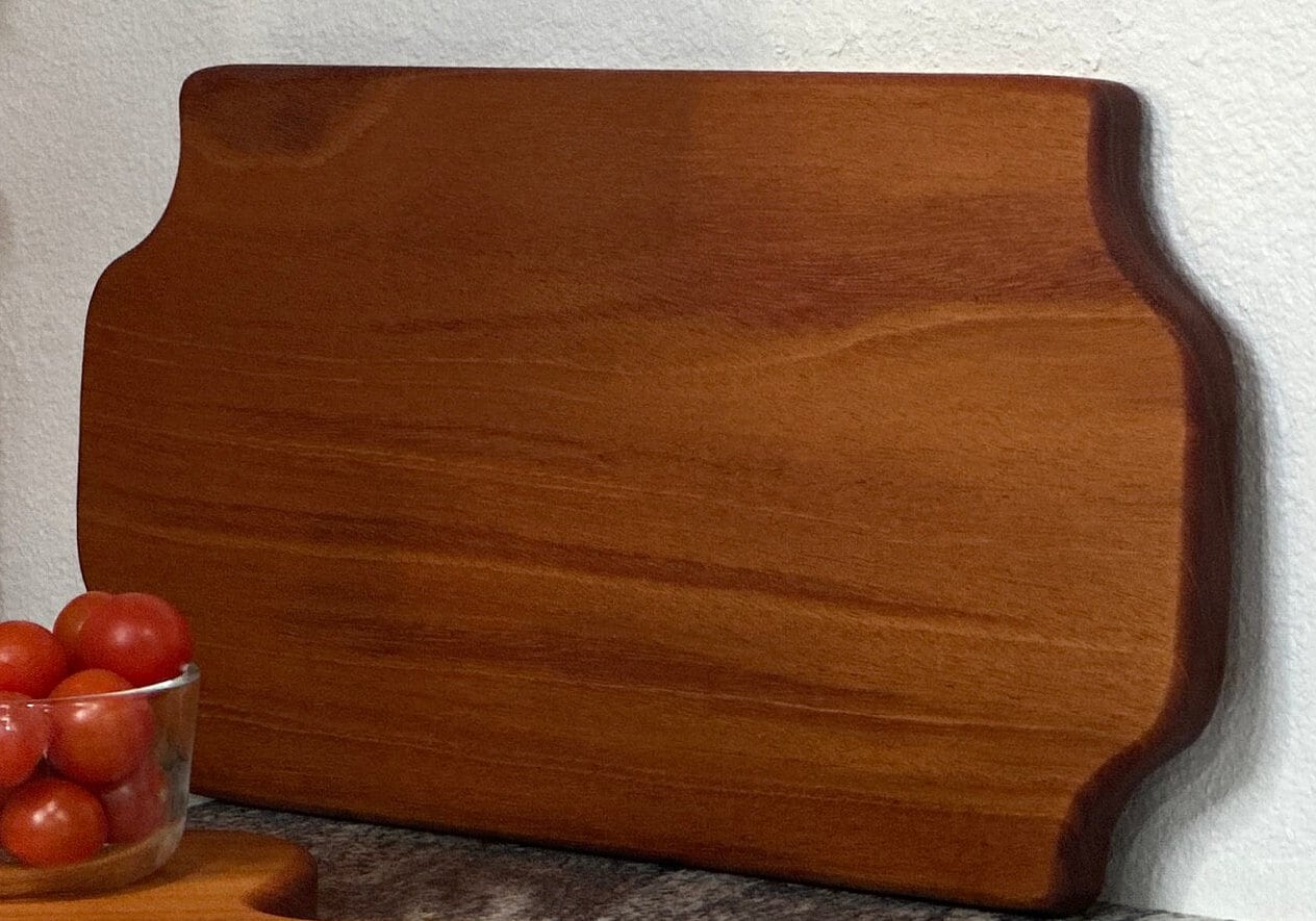 Mahogany red hardwood tray style charcuterie board with bowl of cherry tomato