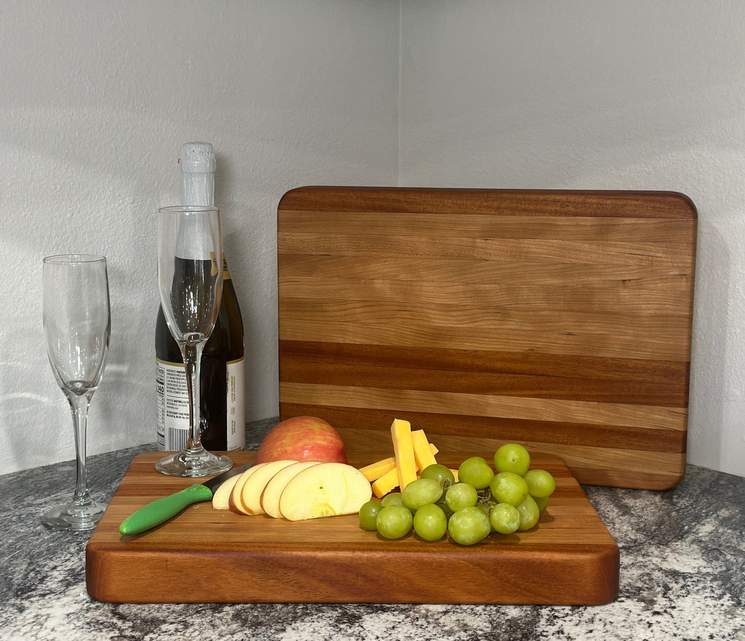 Set of 4 wooden coasters with stand, displaying a glass of ice water and vase with a sunflower photo in the background.