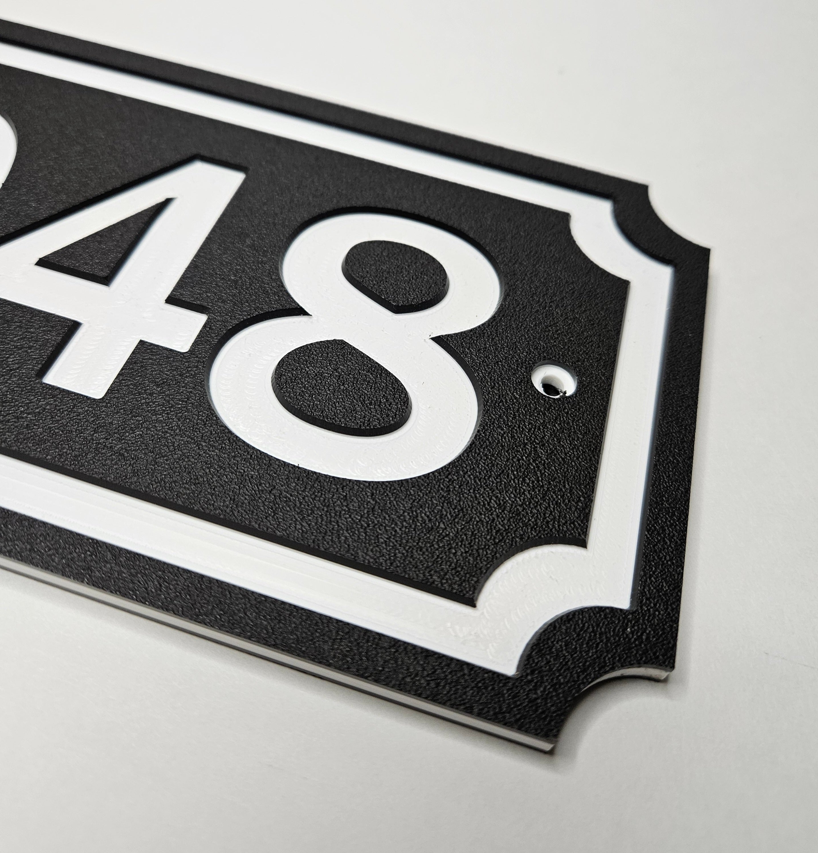 Black and white carved HDPE address sign showing layered material and border detail