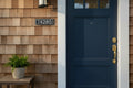 Black and white 2-inch HDPE address sign mounted beside a navy blue front door