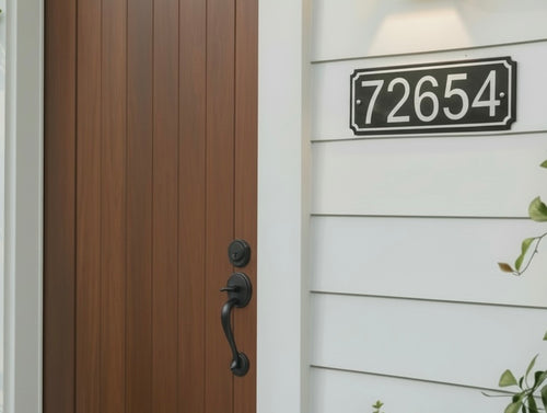 Black and white 4-inch HDPE address sign mounted beside a modern wood front door