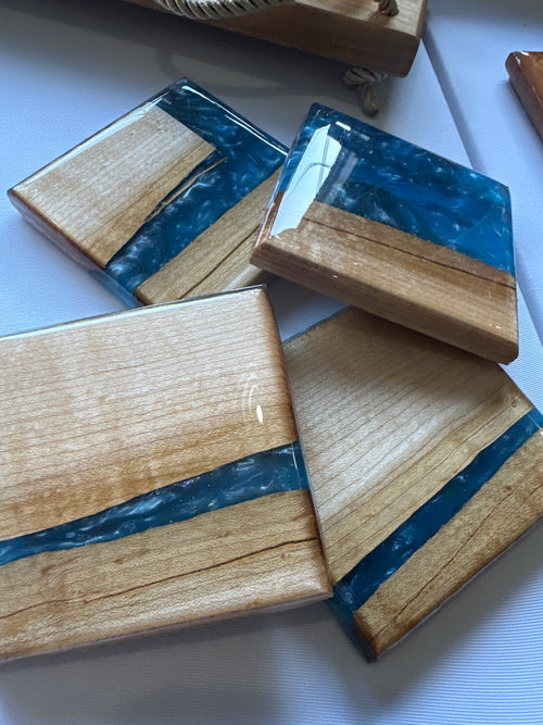 Wooden coasters with blue resin inlay on a white table