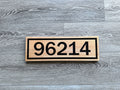 Custom horizontal wood address sign with carved black house numbers and border on a natural wood face