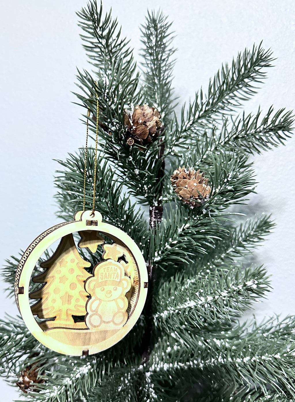 Close up view of 3d wooden ornament with Team Santa bear and tree.