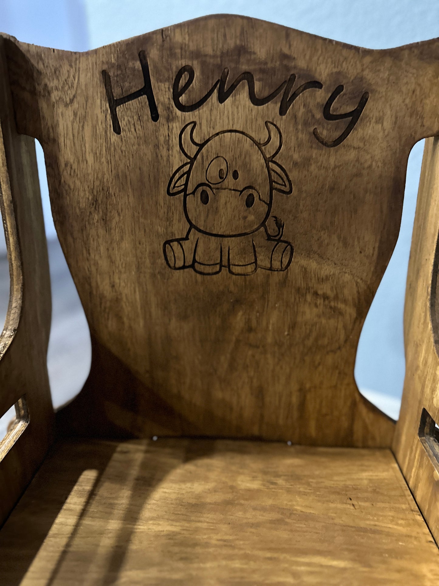 Dark stain rocking chair back with Henry name and baby cow engraving