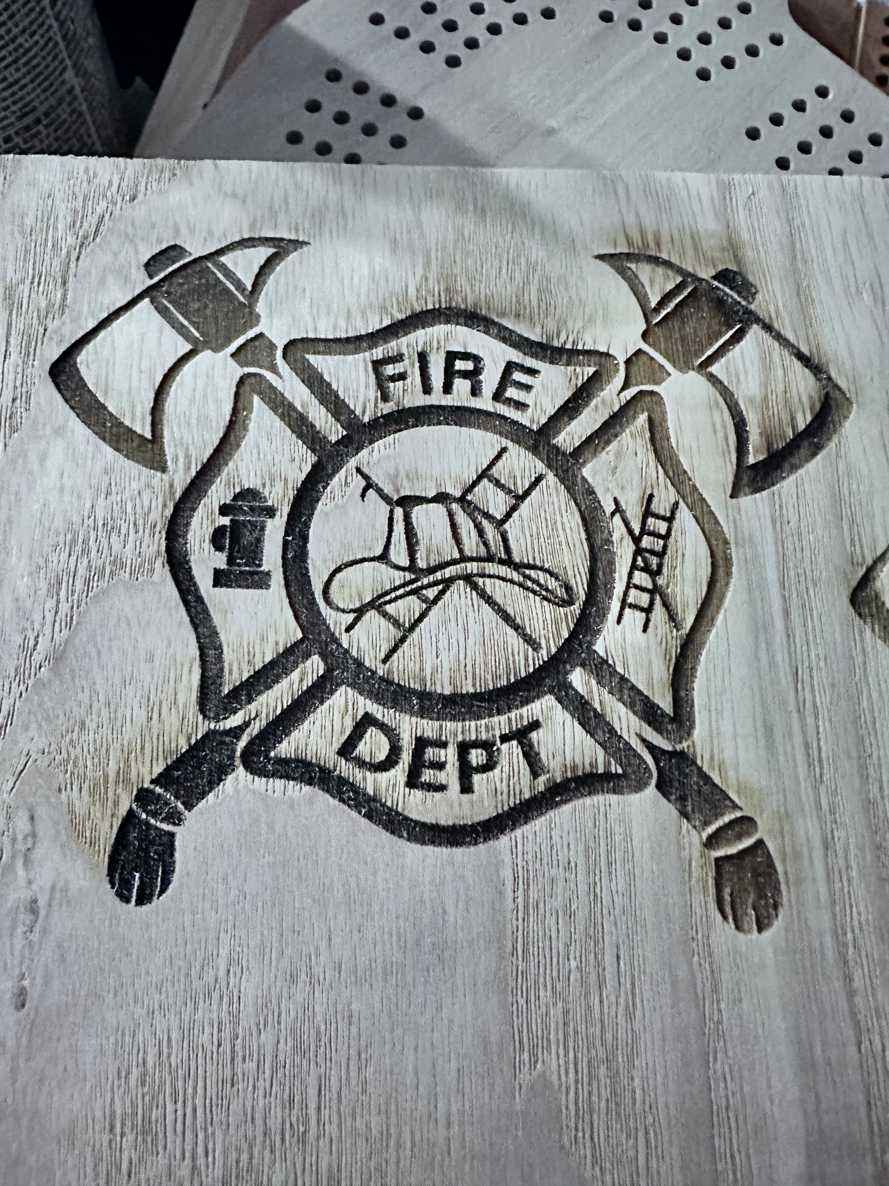 Fire Dept emblem engraving on light wood 