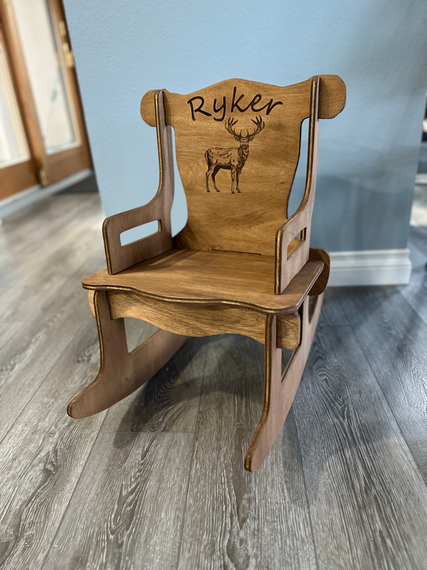 Dark stain rocking chair with Ryker name and buck engraving