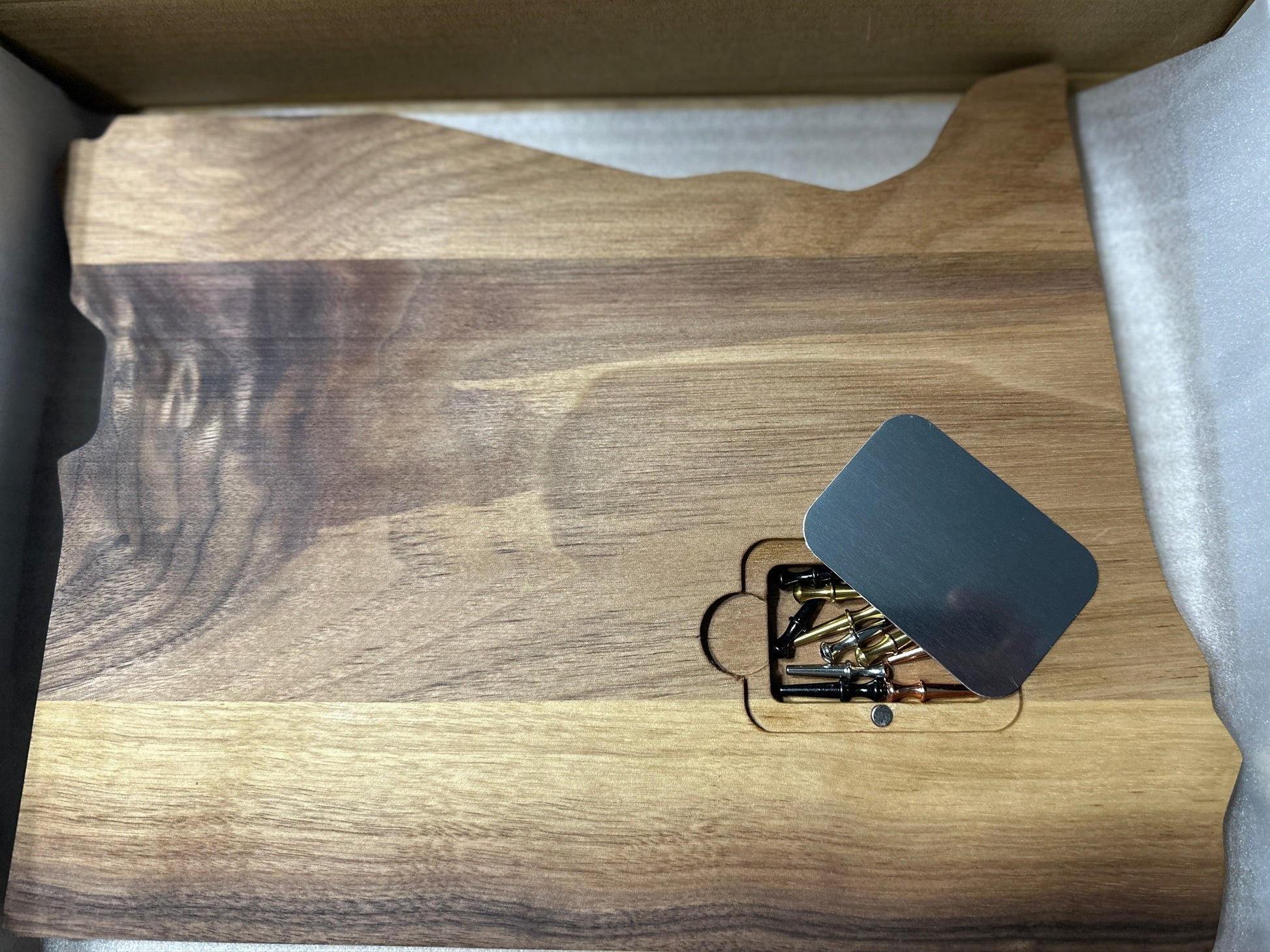 Back of cribbage board state of Oregon shape displaying peg pocket with magnetic metal cover & pegs