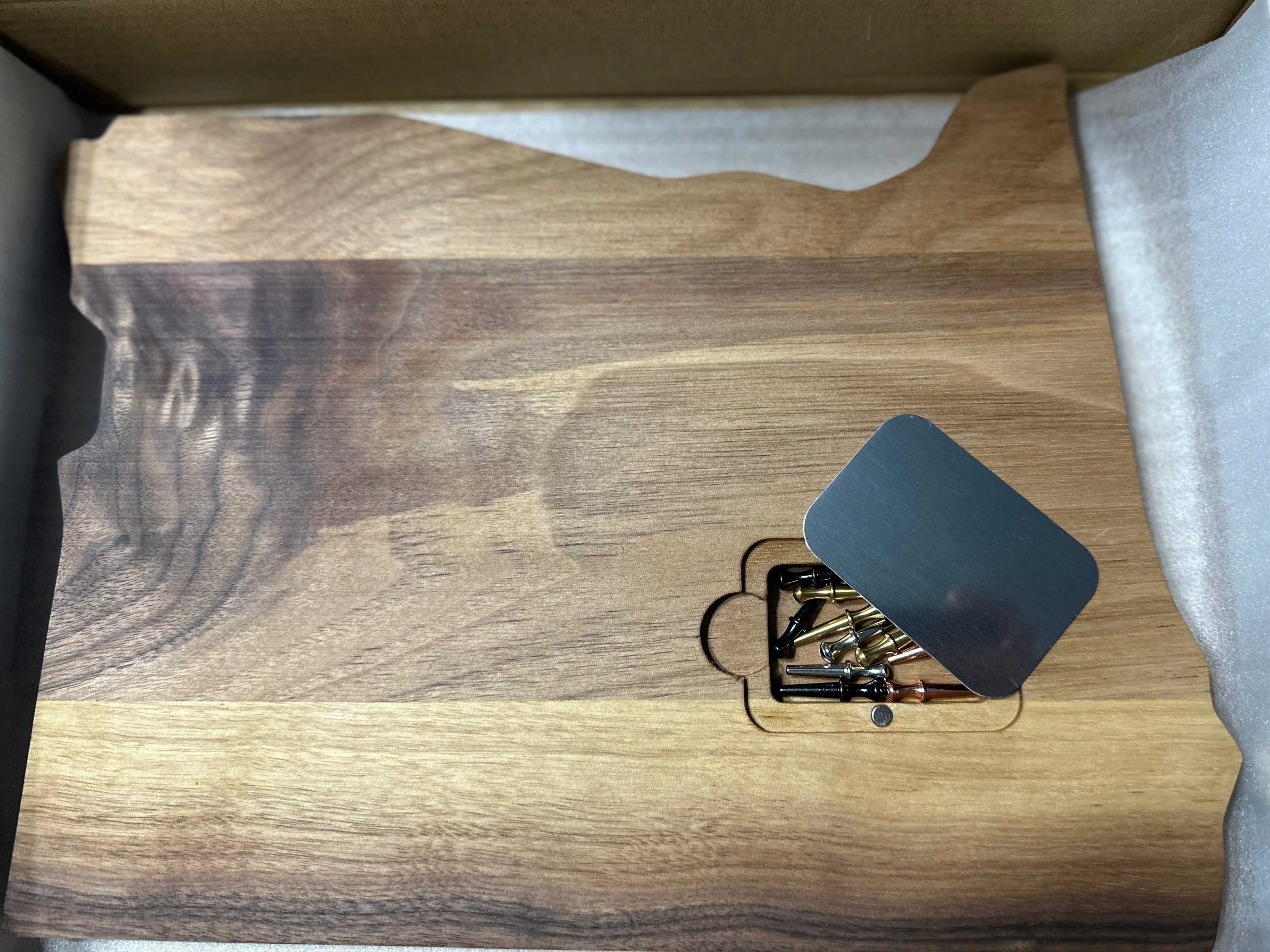 Back of cribbage board state of Oregon shape displaying peg pocket with magnetic metal cover & pegs
