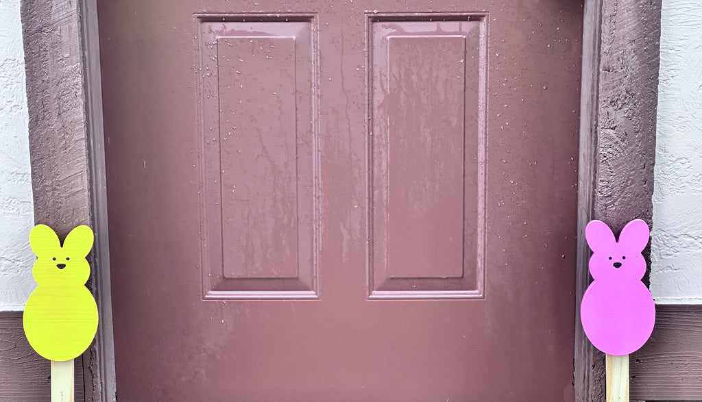 Yellow peeps bunny & Pink Peeps Bunny 18 inch yard stakes on either side of brown door