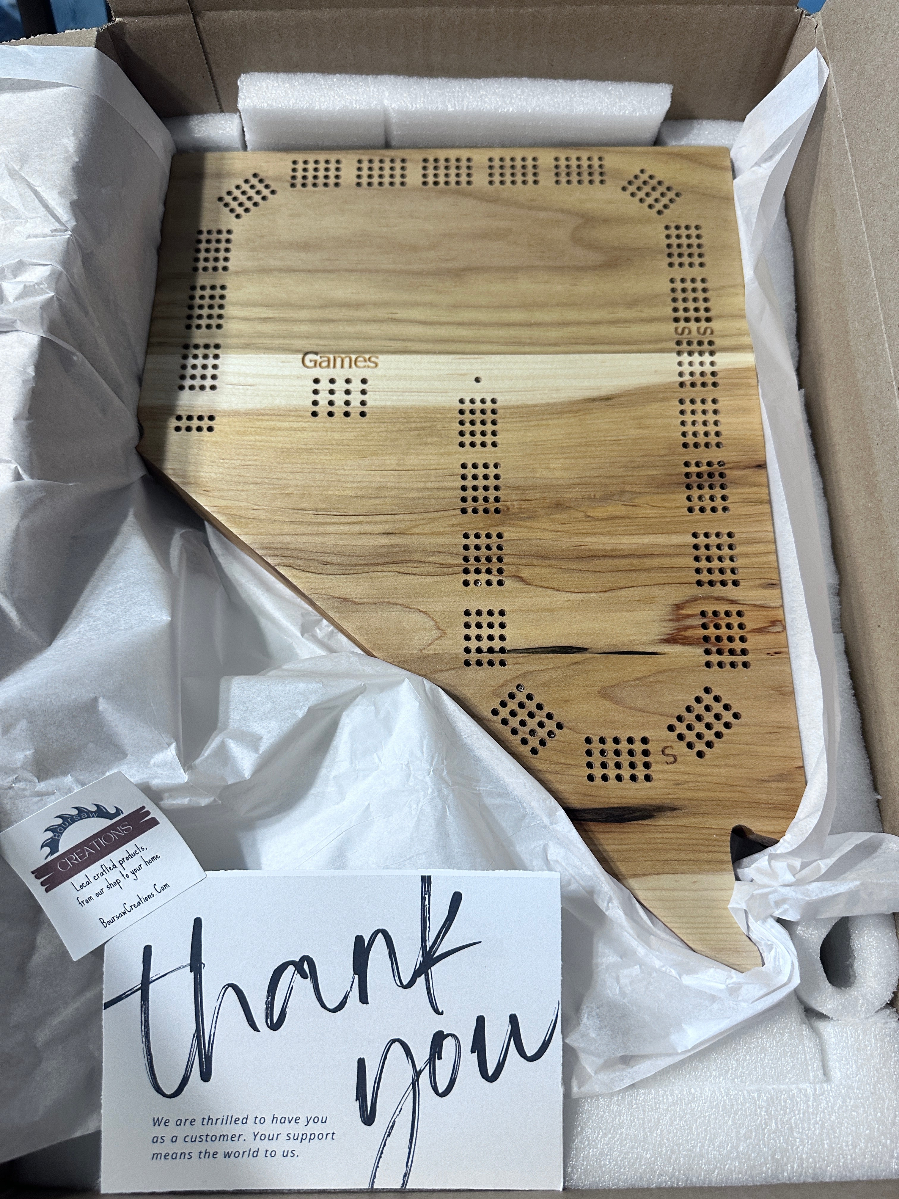 Nevada calico maple cribbage board boxed up with white tissue paper, accompanied by a 'thank you' card.