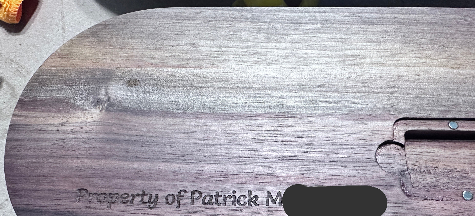 back of Oval hardwood cribbage board with Property of Patrick M and Peg holder