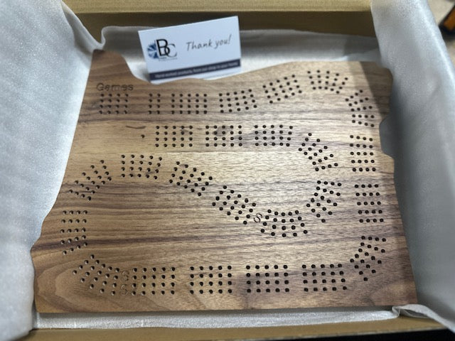 Calico walnut Oregon cribbage board in a shipping box, featuring a 'Thank you!' card.