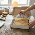 Person unpacking an Oregon calico maple cribbage board from a box on a birthday decorated table.