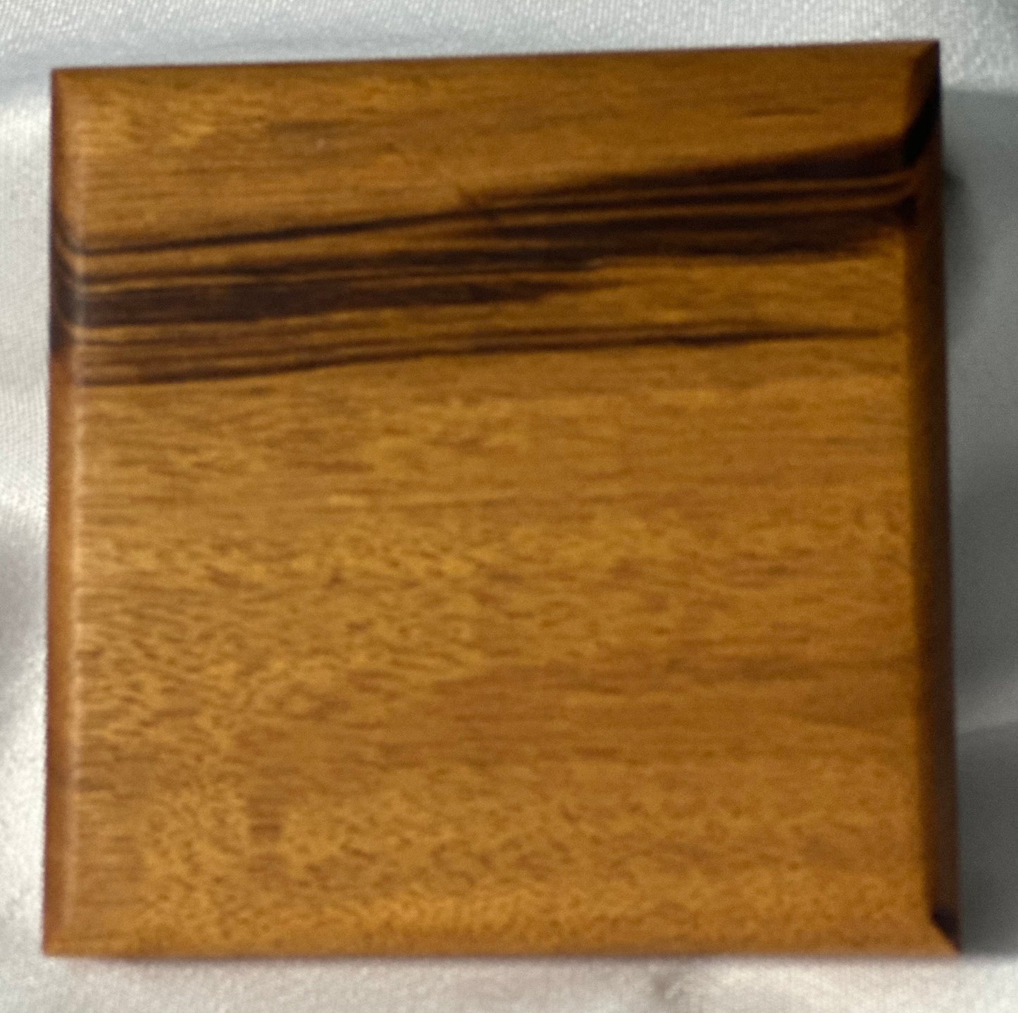 Close up top view of a Brazil wood coaster showing the grain contrast and color - brown.