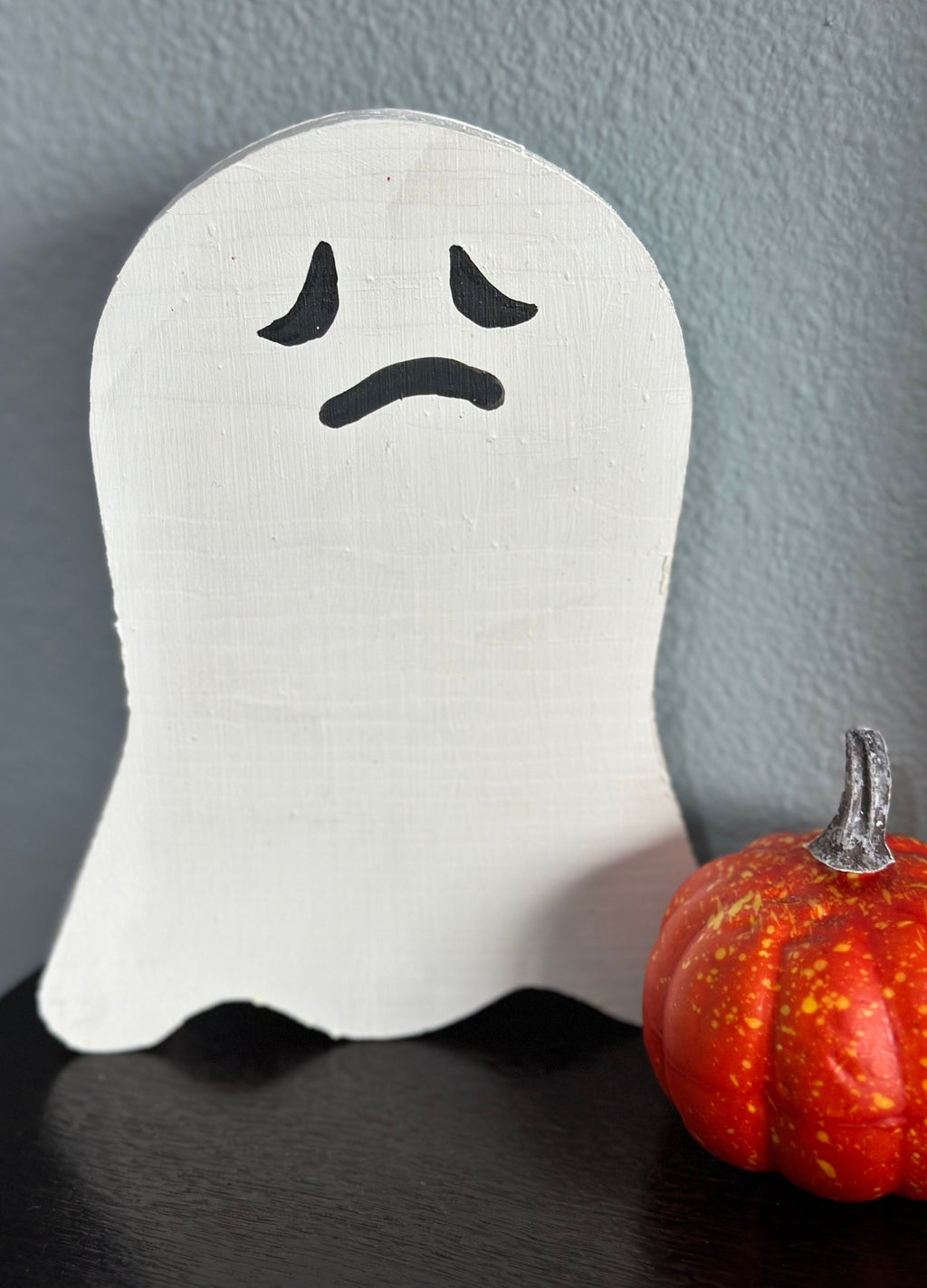 wooden ghost with frown by pumpkin