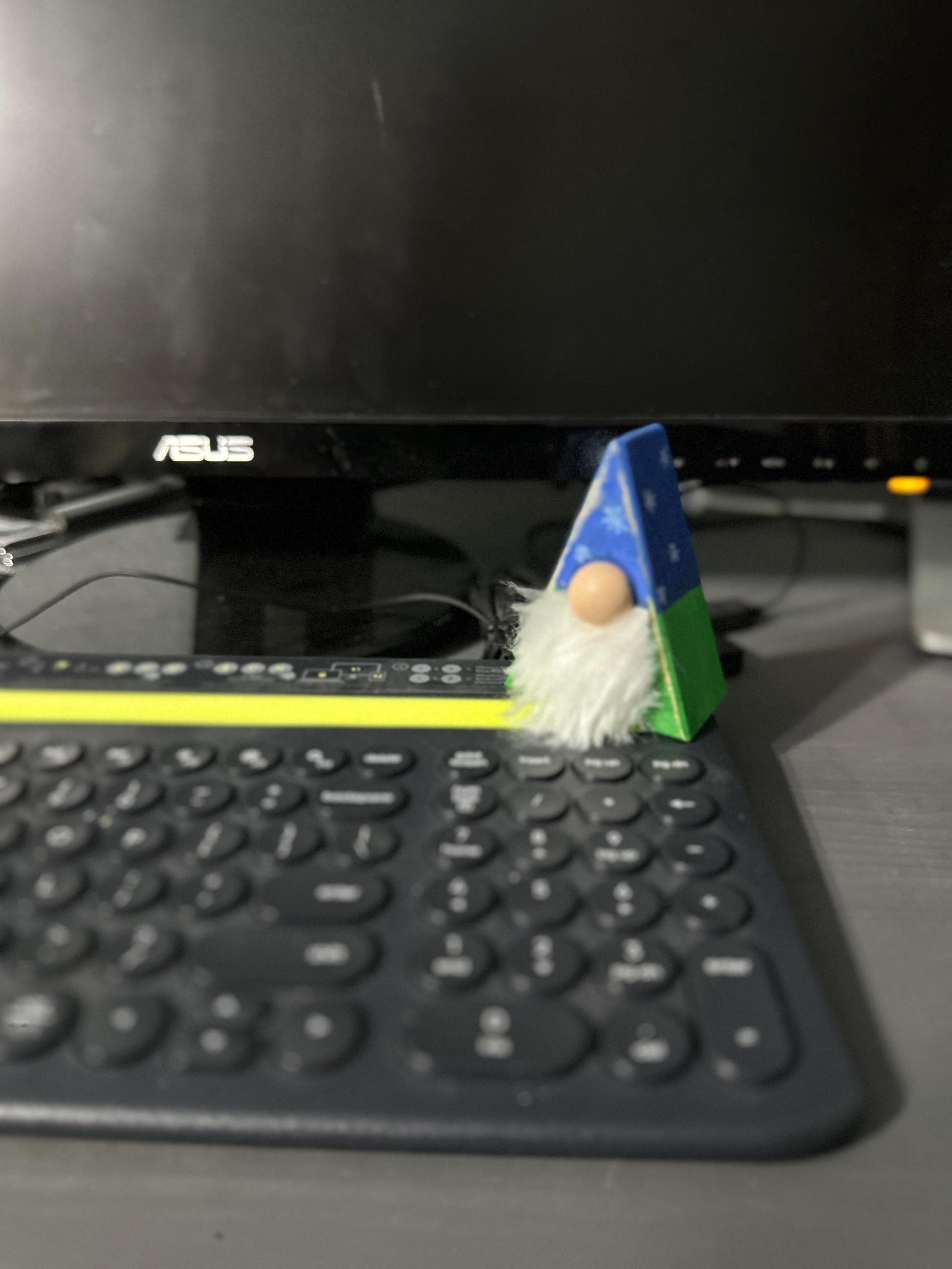 triangle gnome with painted antiqued hat sitting on keyboard