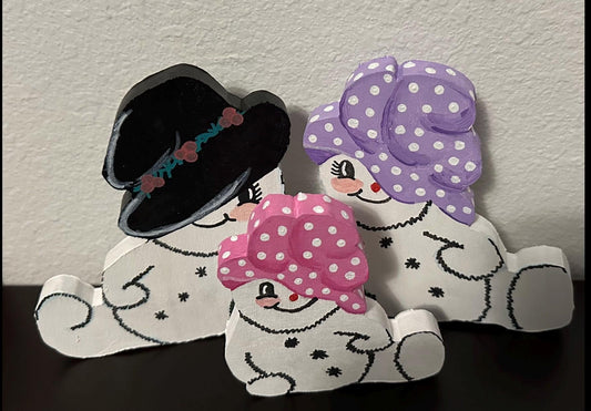 Wood painted snow man with top hat and 2 snow woman shelf sitters with pink & purple painted caps