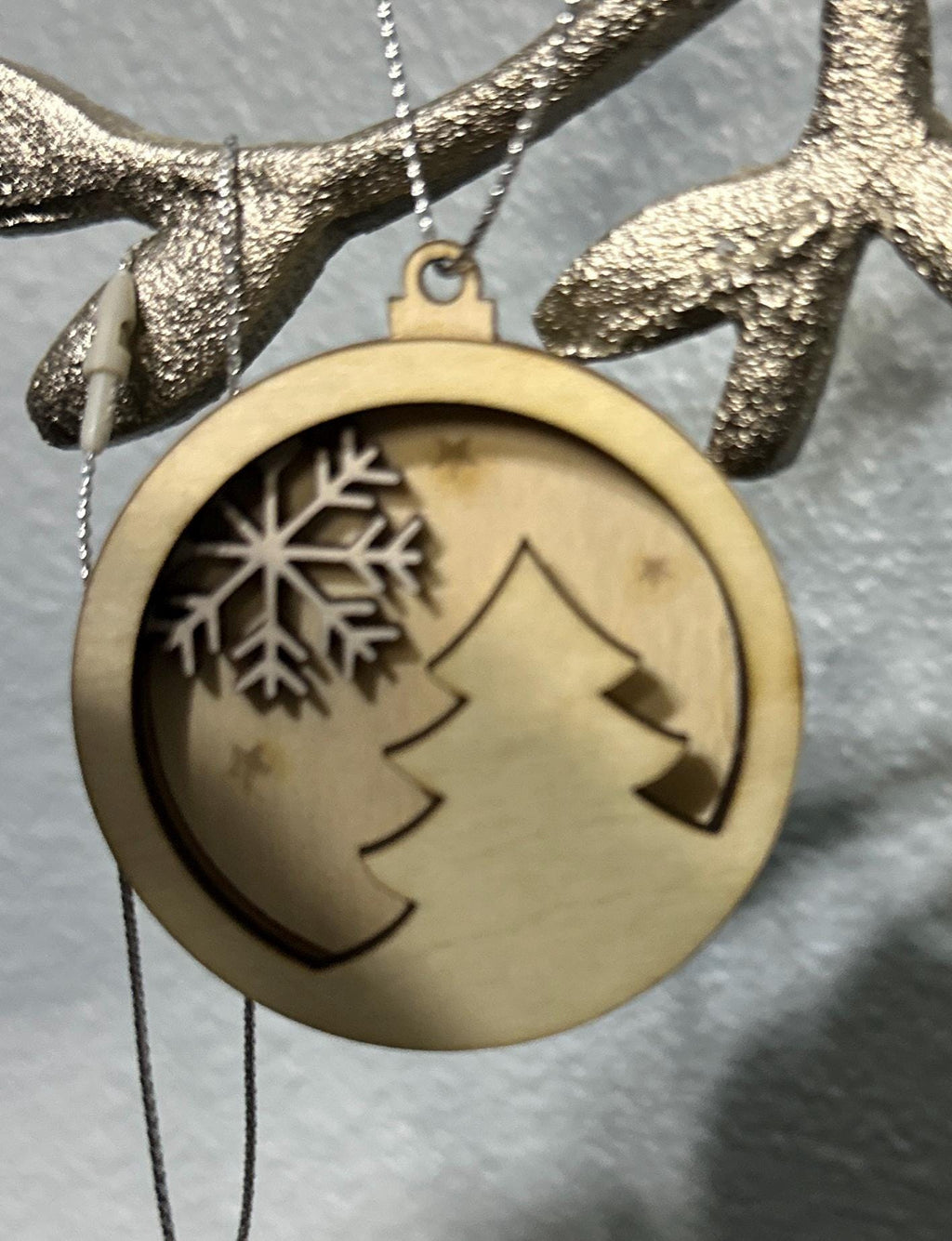 Zoomed in view of Christmas tree and white snowflake ornament