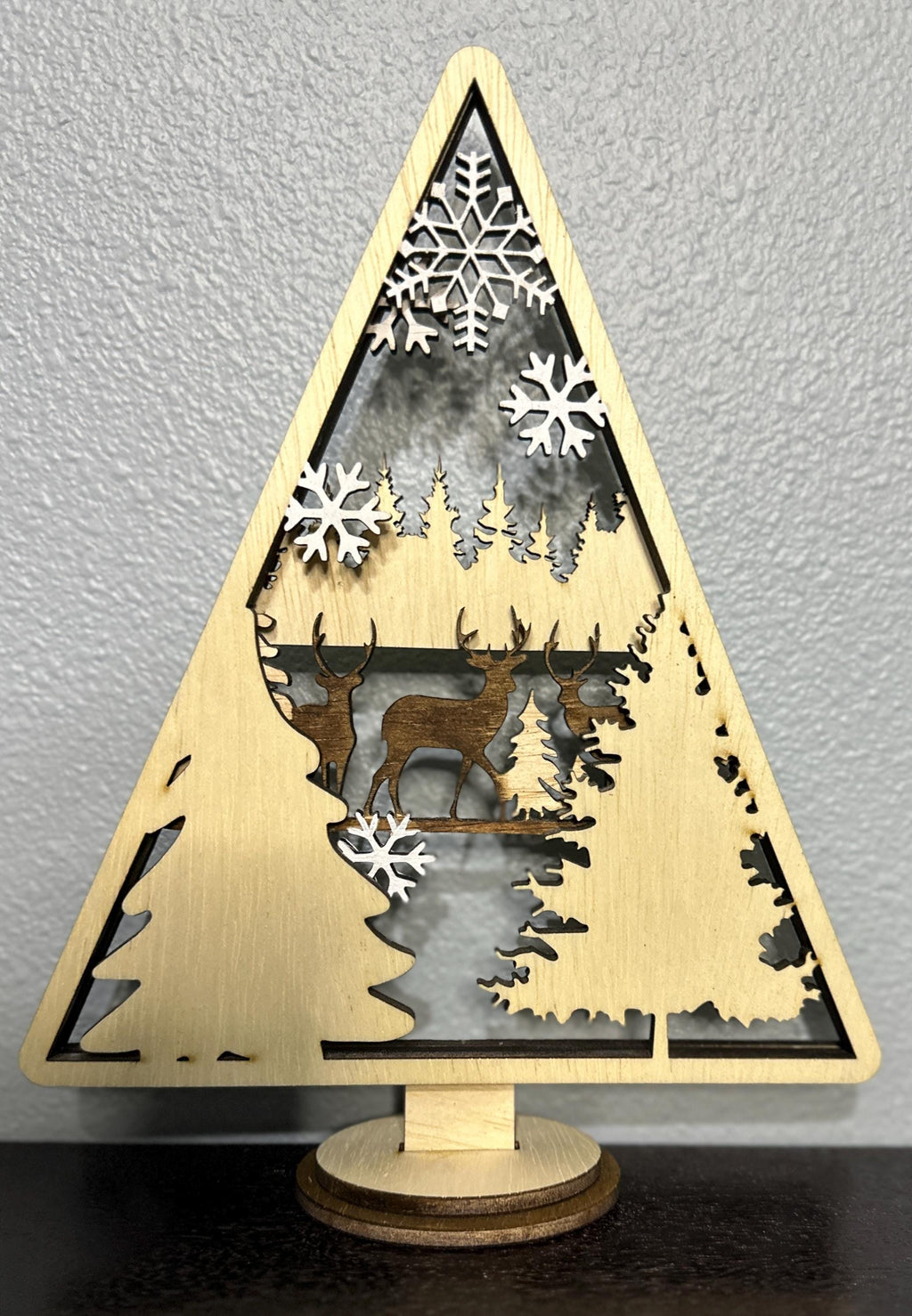 Wood layered triangle decor with stained dark deer with tree and white painted snowflake accents