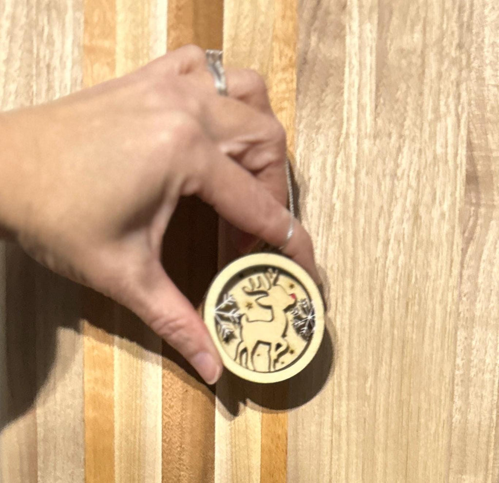 Zoomed in view of Rudolph ornament held between finger and thumb to show 2 inch size