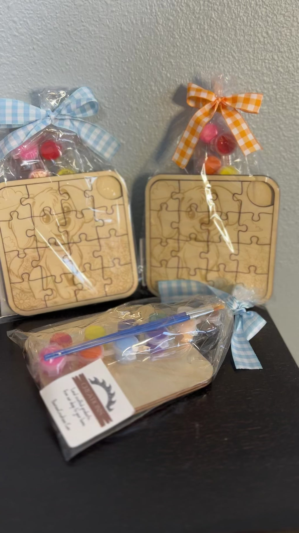video of wooden puzzles 5-inch with paint supplies and ribbons  of cute puppy pre-packaged with checkered ribbon