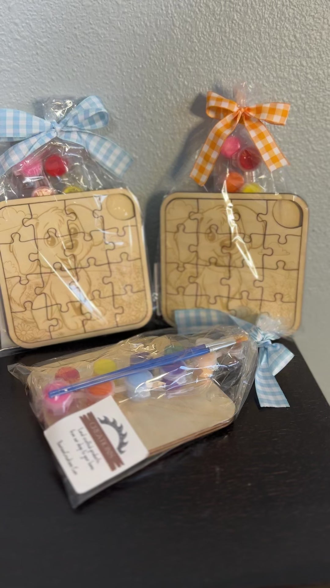 video of wooden puzzles 5-inch with paint supplies and ribbons  of cute puppy pre-packaged with checkered ribbon