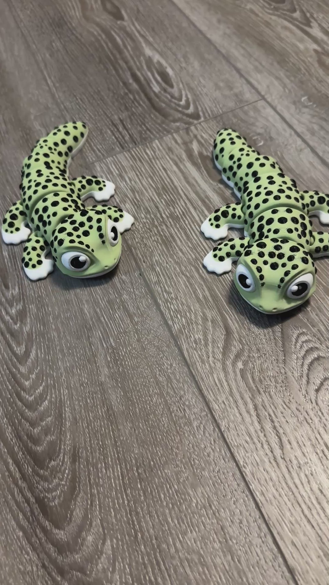 Video of 2 Jumbo 3D printed green Geckos showing movement of articulated body and up close of cartoon style big eyes and smile
